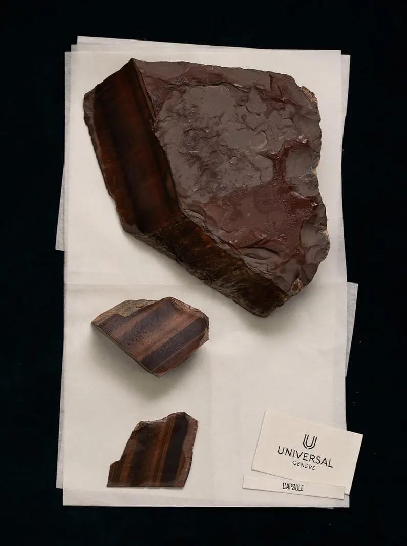 Échantillons d’œil-de-tigre près d’une carte Universal Genève Capsule aux riches nuances brunes