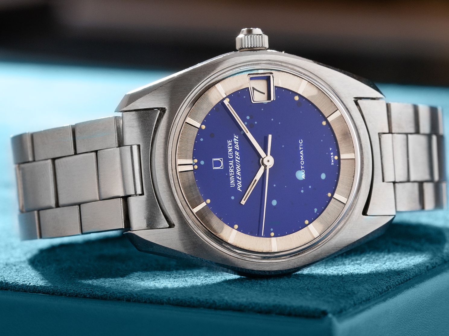 Universal Genève Polerouter Date au cadran bleu moucheté et bracelet acier sur écrin turquoise raffiné