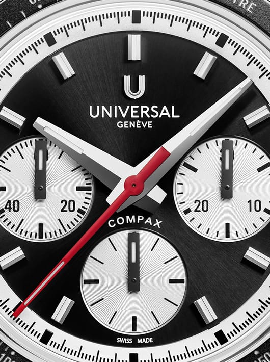 Gros plan du cadran noir Universal Genève Compax avec compteurs argentés et aiguille rouge centrale