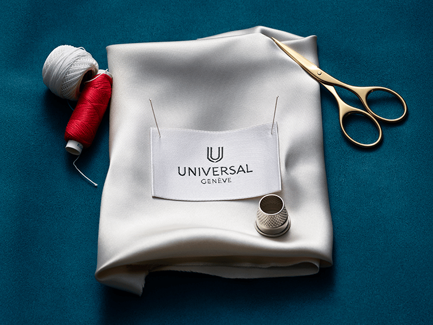 {generated} Étiquette Universal Genève épinglée sur tissu blanc avec ciseaux, fil et dé pour article magazine raffiné