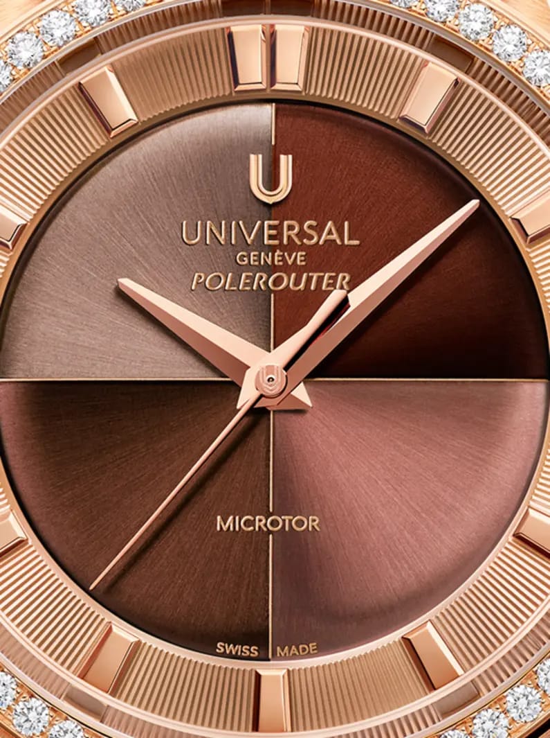 Gros plan du cadran Universal Genève Polerouter aux index or rose, finitions brunes et diamants